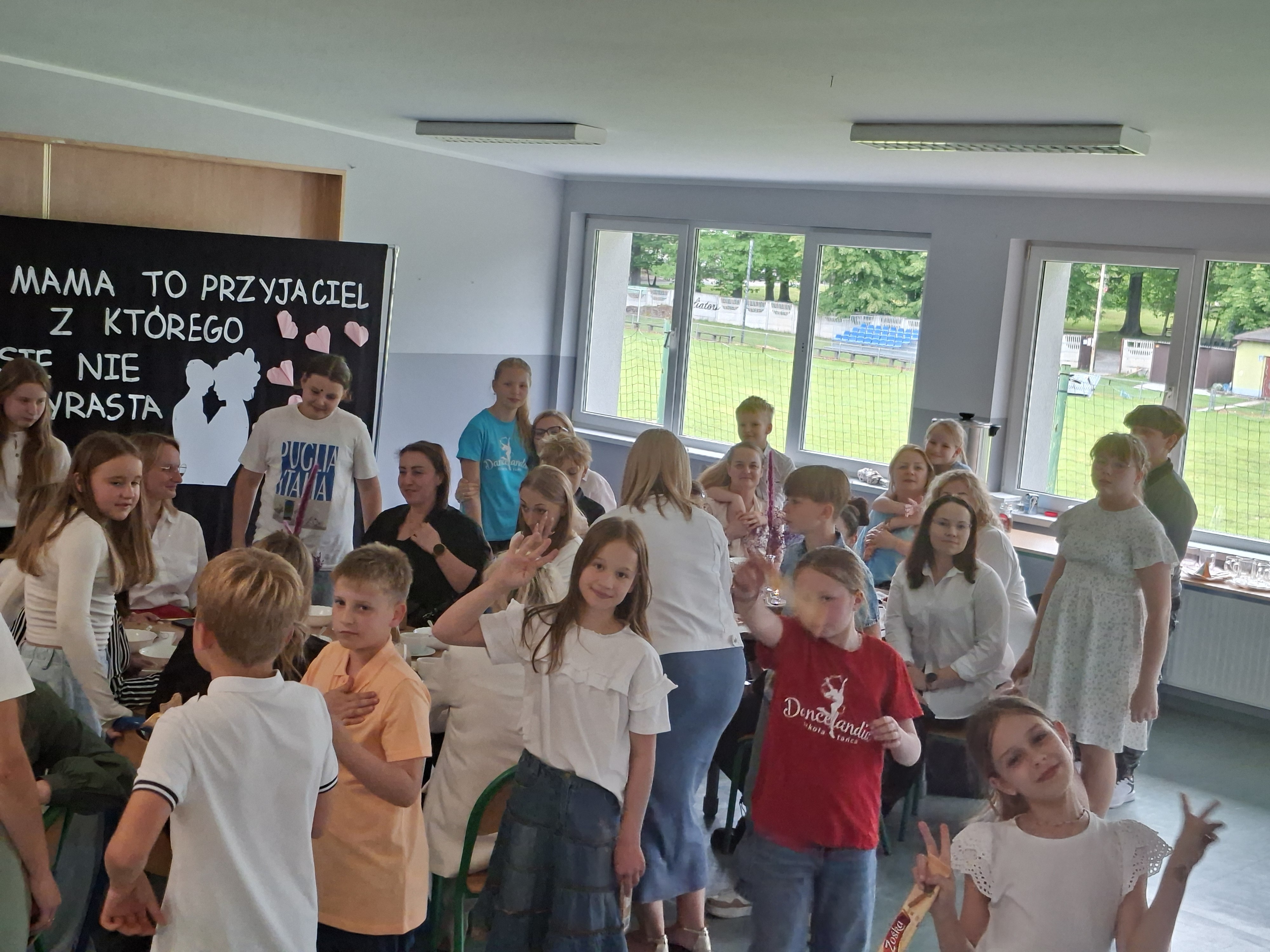 Uczniowie klasy czwartej wraz z mamami w trakcie uroczystości klasowej.